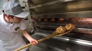 Ein Bäckermeister schiebt einen Laib Brot in den Ofen (Foto: picture alliance / dpa | Nicolas Armer)
