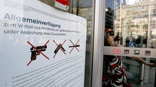 Ein Plakat hängt am Eingang des Hauptbahnhofes und informiert über das Waffenverbot. (Foto: dpa/Oliver Berg)