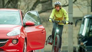 Eine Frau weicht auf dem Fahrradweg einer Autotür aus (Foto: picture alliance/dpa | Marijan Murat)
