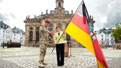 Archivbild: 06.09.2011, Oberst Frank Rapp (Saarlandbrigade) übergibt der damaligen Ministerpräsidentin Annegret Kramp-Karrenbauer (CDU) anlässlich eines Rückkehrappells auf dem Ludwigsplatz in Saarbrücken ein Flagge des Saarlandes (Foto: dpa / picture alliance / Oliver Dietze)