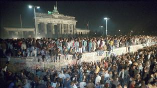 10.11.1989, Berlin: Menschen auf der Berliner Mauer vor dem Brandenburger Tor in der Nacht vom 9. auf den 10.11.1989.  (Foto: dpa / picture alliance / Peter Kneffel)