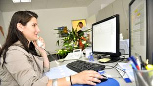 Eine Auszubildende sitz mit dem Telefonhörer am Ohr vor dem Computer im Büro (Foto: picture alliance / dpa | Marius Becker)