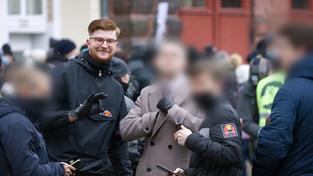 Nicolas Benyoucef zeigt das sog. „White Power“-Zeichen bei einer Anti-Corona-Demo Anfang 2022 in Saarbrücken – Weichgezeichnete Gesichter durch die Redaktion unkenntlich gemacht (Foto: Kai Schwerdt)