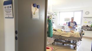 Ein Arzt oder Pfleger im Patientenzimmer bei der Behandlung (Foto: SR)