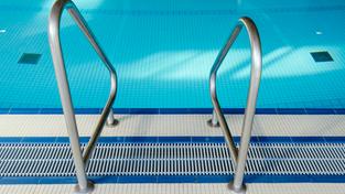 Eine Leiter ist im Hallenbad vor einem Schwimmbecken zu sehen. (Foto: picture alliance/dpa | Uwe Anspach)
