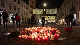 Kerzen und Menschen stehen abends zur Andacht an einem der Tatorte wo ein 51-jähriger Mann mit einem Geländewagen durch die Fußgängerzone gerast und dabei fünf Menschen getötet hat (Foto: picture alliance/dpa | Harald Tittel)