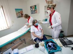 Mitarbeitende einer Arztpraxis und Patientin mit medizinischen Mund-Nasen-Masken (Foto: picture alliance/dpa/Reuters/Pool | Hannibal Hanschke)