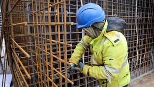 Ein Bauarbeiter montiert auf einer Großbaustelle (Foto: picture alliance/dpa | Christian Charisius)