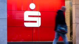 Passanten laufen an einer Filiale der Sparkasse vorbei (Foto: picture alliance/dpa | Julian Stratenschulte)