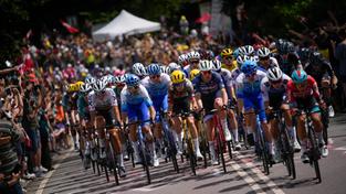 Tausende Zuschauer feuern am Straßenrand die Sportler während einer Etappe der Tour de France an. (Foto: picture alliance/dpa/AP | Daniel Cole)