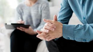 Ein Mann sitzt während einer Sitzung bei einer Psychotherapeutin auf der Couch. (Foto: picture alliance / Zoonar | Oleksandr Latkun)