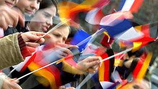 Eine Menschenmenge wedelt mit kleinen Nationalflaggen von Deutschland und Frankreich (Foto: picture-alliance / dpa | Michael Hanschke)