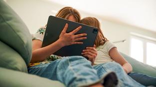 Zwei Kinder sitzen mit einem Tablet auf der Couch (Foto: picture alliance/dpa | Annette Riedl)