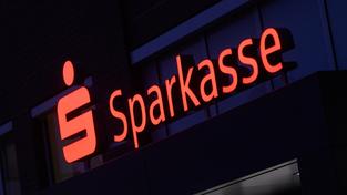 Beleuchtetes Logo der Sparkasse (Foto: picture alliance/dpa | Julian Stratenschulte)