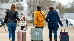 Drei aus der Ukraine stammende Frauen gehen mit ihren Habseligkeiten in Koffern zu ihrem Quartier (Foto: picture alliance/dpa | Stefan Puchner)