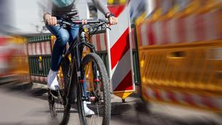 Eine Fahrradfahrerin fährt durch eine Baustelle. (Foto: picture alliance / CHROMORANGE | Udo Herrmann)