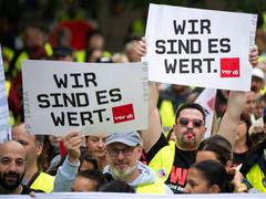 Teilnehmer der Kundgebung halten Schilder mit der Aufschrift „Wir sind es wert“ hoch (Foto: picture alliance/dpa | Hannes P Albert)