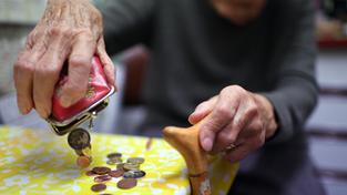 Eine Seniorin schüttet Münzen aus ihrem Geldbeutel auf den Küchentisch (Foto: picture alliance/dpa | Felix Kästle)