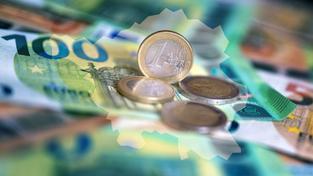 Geldscheine und Münzen liegen auf einem Tisch, darüber sind die Umrisse des Saarlandes gelegt (Foto: picture alliance/dpa | Monika Skolimowska)