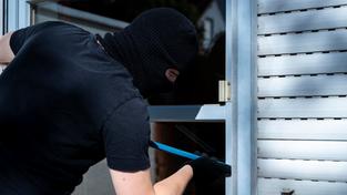 Symbolbild: Maskierter Einbrecher hebelt mit einem Brecheisen die Türe von einer Terasse von einem Haus auf. (Foto: picture alliance / CHROMORANGE | Michael Bihlmayer)