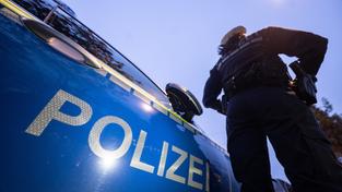 Eine Polizistin steht neben einem Polizeifahrzeug. (Foto: picture alliance/dpa | Marijan Murat)