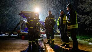 Einsatzkräfte von THW und Feuerwehr stehen bei Starkregen an einer Pumpe. (Foto: picture alliance/dpa | Philipp Schulze)