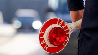 Ein Polizist hält eine Anhaltekelle in der Hand (Foto: picture alliance/dpa | Marcus Brandt)