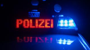 Polizisten stehen nachts vor einem Polizeifahrzeug  (Foto: picture alliance/dpa | Marijan Murat)