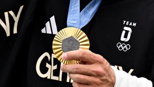 Ein Sportler des deutschen Olympia-Teams präsentiert seine Goldmedaille der olympischen Spiele Paris 2024 (Foto: picture alliance/dpa | Sebastian Kahnert)