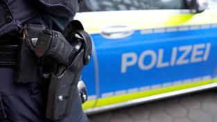 Ein Polizist steht vor einem Einsatzfahrzeug der Polizei. (Foto: picture alliance/dpa | Marcus Brandt)