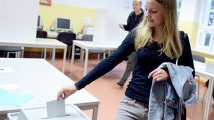 Eine junge Wählerin wirft ihren Stimmzettel in die Wahlurne (Foto: picture alliance / dpa | Britta Pedersen)