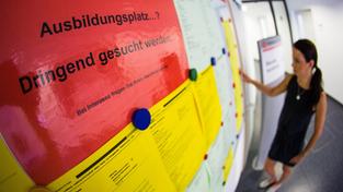 Eine junge Frau schaut sich Aushänge mit freien Ausbildungsplätzen an. (Foto: picture alliance / dpa | Christoph Schmidt)
