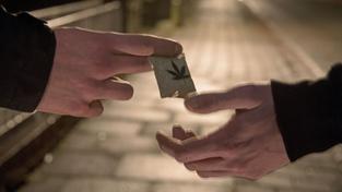 Eine gestellte Szene zeigt zwei Männer bei der Übergabe eines Tütchen Marihuanas auf einer Straße (Foto: picture alliance / Ingo Wagner/dpa | Ingo Wagner)