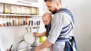 Elternzeit. Vater mit Baby erledigt den Abwasch. (Foto: picture alliance / Westend61 | HalfPoint)