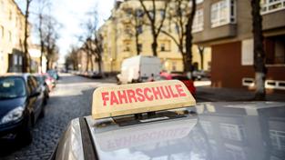 Ein Schild mit der Aufschrift „Fahrschule“ ist auf dem Dach eines Fahrschulwagens montiert (Foto: picture alliance / Gregor Fischer/dpa | Gregor Fischer)