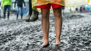 Ein Festivalbesucher steht barfuß im Matsch und hält Gummistiefel in der Hand (Foto: picture alliance / Sebastian Gollnow/dpa | Sebastian Gollnow)