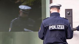 Ein Polizist steht in Uniform vor einer Haustür (Foto: picture alliance / Frank Rumpenhorst/dpa | Frank Rumpenhorst)