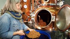 Brennerin Margot Guillon schippt die Speierlingfrüchte in den Brennkessel (Foto: SR)