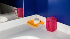 Ecke eines Waschtisches mit Spiegel, Seifenbehälter und Zahnputzbecher vor einer blauen Wand (Foto: Lukas Ratius)