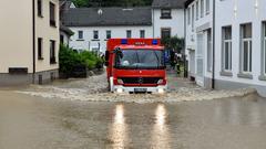 Die Bugwelle eines durchfahrenden Feuerwehrfahrzeugs bei Hochwasser in Fechingen schwappt bis unter die Fensterbänke eines Wohnhauses (Foto: BeckerBredel)