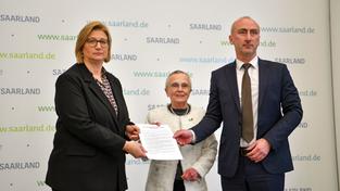 Anke Rehlinger, Ricarda Kunger und Rasim Akkaya halten eine unterzeichnete Erklärung in Händen (Foto: BeckerBredel)