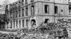 Saarbrücken, Soldat mir einem von der Wehrmacht beschlagnahmten Zivilfahrzeug vor dem von Bombenangriffen zerstörten Palais Freital am Ludwigsplatz Handschriftlich auf der Rückseite: „Ludwigsplatz (Postscheckamt) 5./6. Okt 1944“ (Foto: Saarländisches Landesarchiv / Fritz Mittelstaedt)