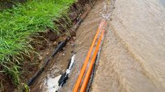 Abfließendes Regenwasser spült Kabel und Wasserleitungen neben einer Straße frei (Foto: SR / Christine Alt)