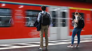 Zugreisende warten im Bahnhof auf die Einfahrt einer S-Bahn (Foto: picture alliance/dpa | Arne Dedert)