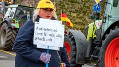 Eine Frau, die sich an den Bauernprotesten am 8. Januar beteiligt hält ein Schild hoch, auf dem seht: "Aufstehen, es betrifft uns alle. Macht mit." (Foto: SR/Sebastian Knöbber)