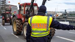Ein Polizist gibt einem Traktor bei einer Demonstration Handzeichen. (Foto: SR/Sebastian Knöbber)