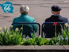  (Foto: Ein Rentner und eine Rentnerin sitzen auf einer Parkbank und schauen auf eine asphaltierte Fläche vor sich)