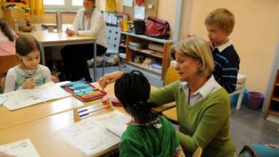 Eine Lehrerin erklärt einer Grundschülerin eine Aufgabe (Foto: dpa)