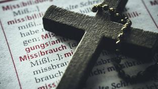 Kreuz auf einem Wörterbuch mit dem Wort "Missbrauch" (Foto: IMAGO / Christian Ohde)