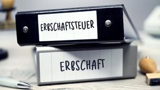 Zwei Ordner mit Aufschrift Erbschaft und Erbschaftsteuer liegen auf einem Tisch. (Foto: IMAGO / Christian Ohde)